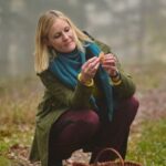 Frau sammelt frische Pilze im Wald für die Pilzmanufaktur Freiburg.